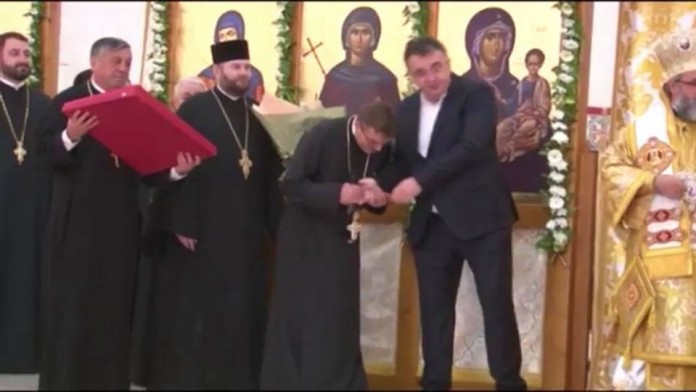 Un preot încearcă să-i sărute mâna liderului PSD, Marian Oprișan